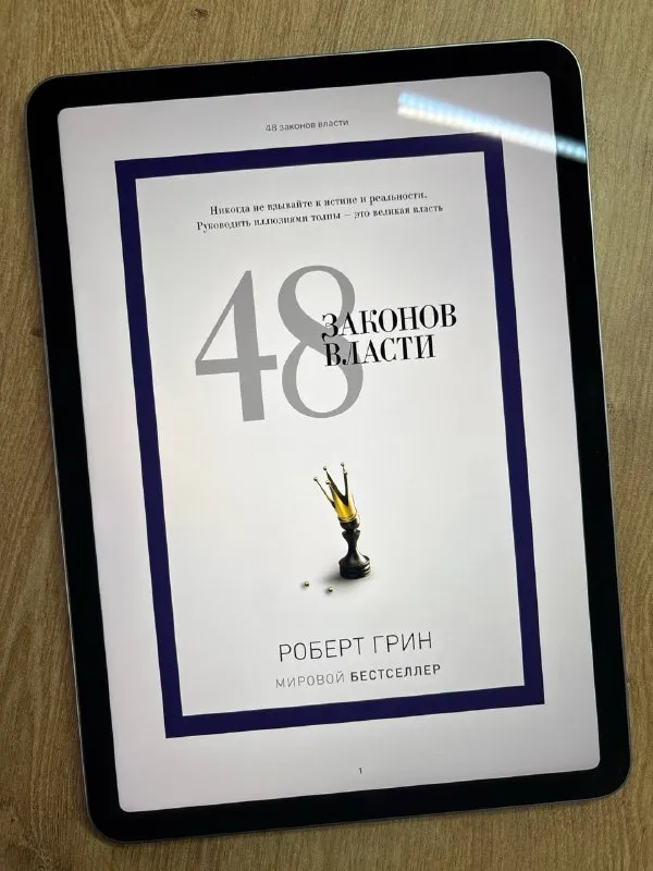 Обложка книги «48 законов власти» Роберта Грина на экране планшета