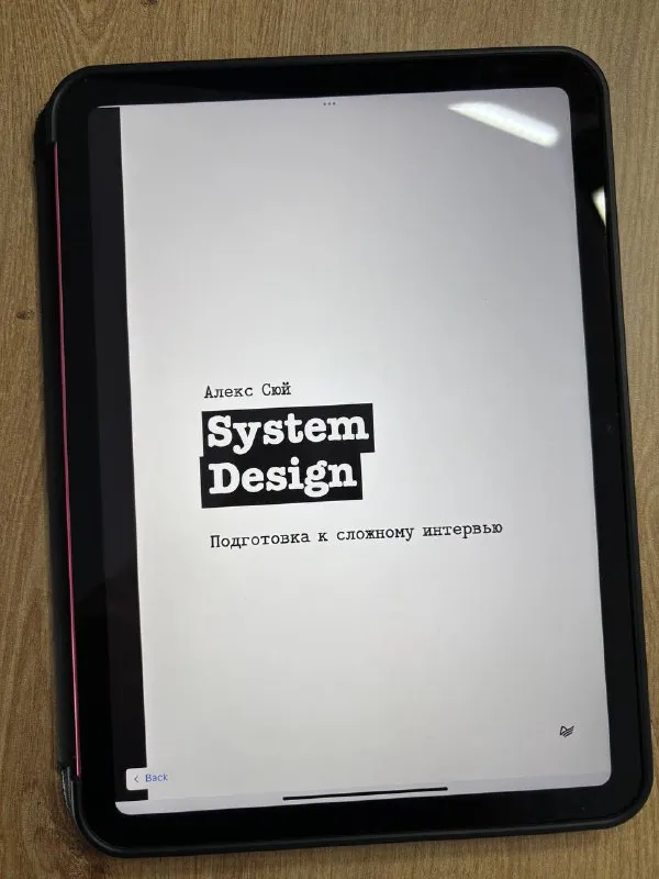 Обложка книги «System Design. Подготовка к сложному интервью» Алекса Сюя на экране планшета